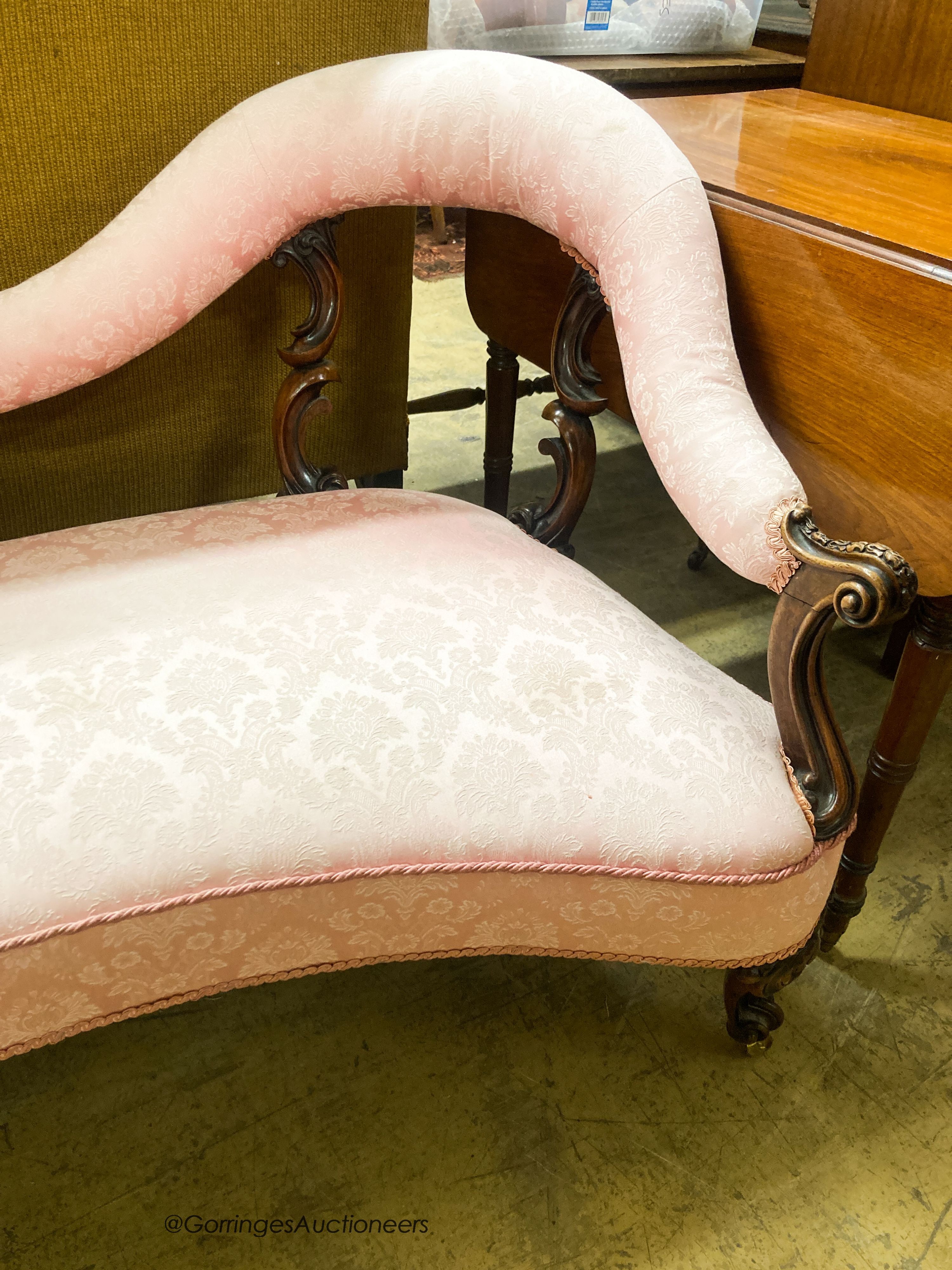 A Victorian walnut love seat, upholstered in floral damask, W.144cm. D.68cm. H.79cm